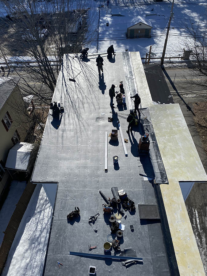 The Caron Construction crew working hard on a large residential roof